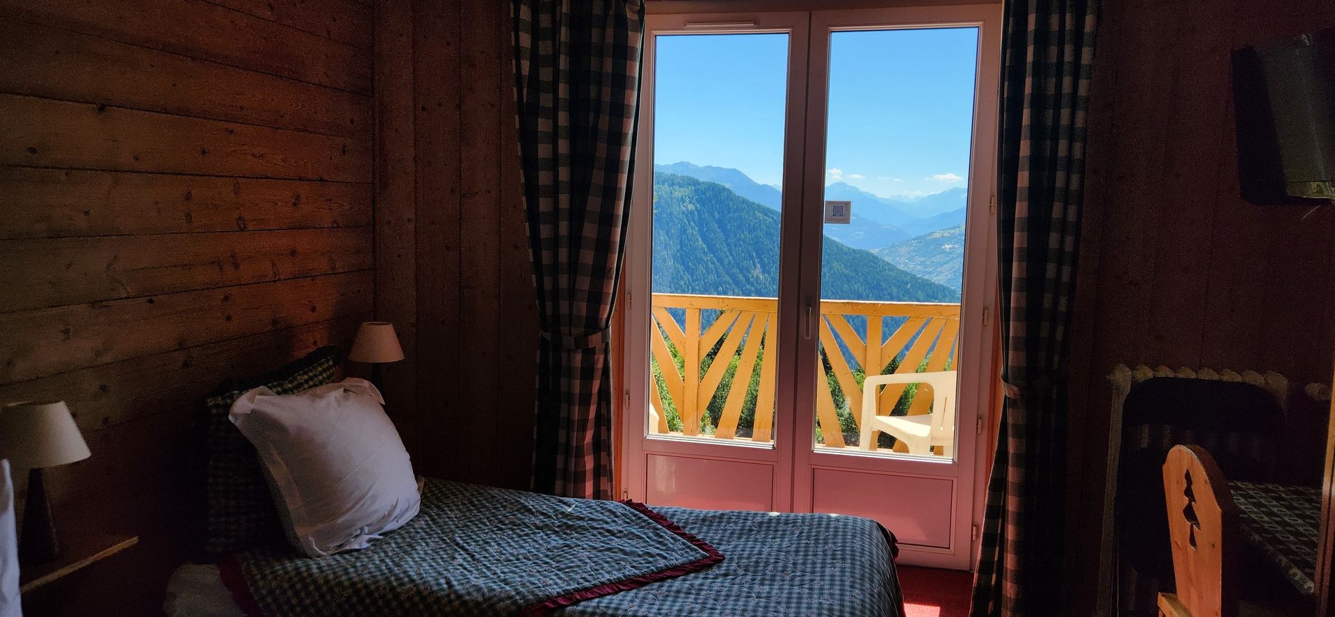 Chambre avec porte-fenêtre ouvrant sur les montagnes